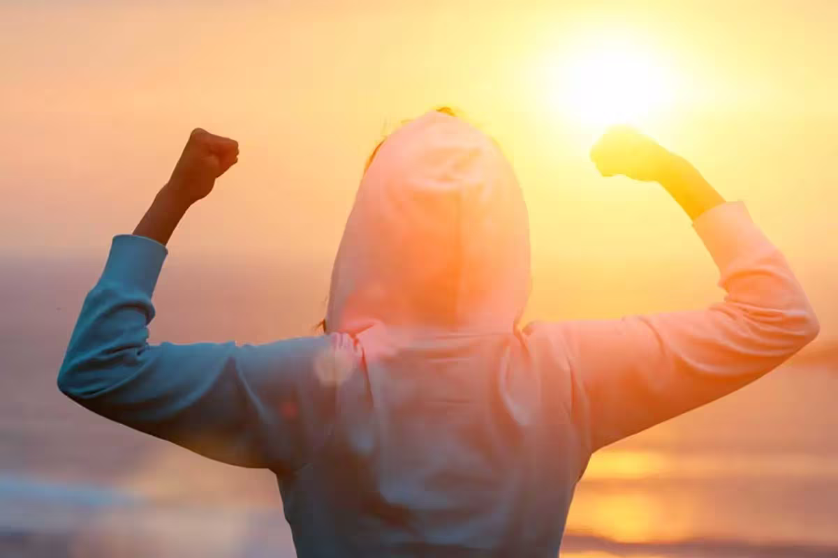 From Resolutions To Reality 3 woman flexing arms while facing the sunset