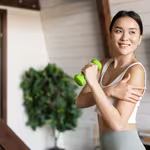 Woman exercising with a small dumbbell, reaping the benefits of a plant-based diet, which includes easing climate change effects