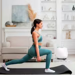 Girl working out with light weights on a yoga mat in her living room with QNET Products such as HomePure Zayn and Chi Pendant 4 helping her with her fitness resolutions