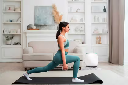 Girl working out with light weights on a yoga mat in her living room with QNET Products such as HomePure Zayn and Chi Pendant 4 helping her with her fitness resolutions