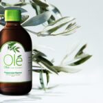 Bottle of Ole Olive Leaf Extract in front of olive leaves