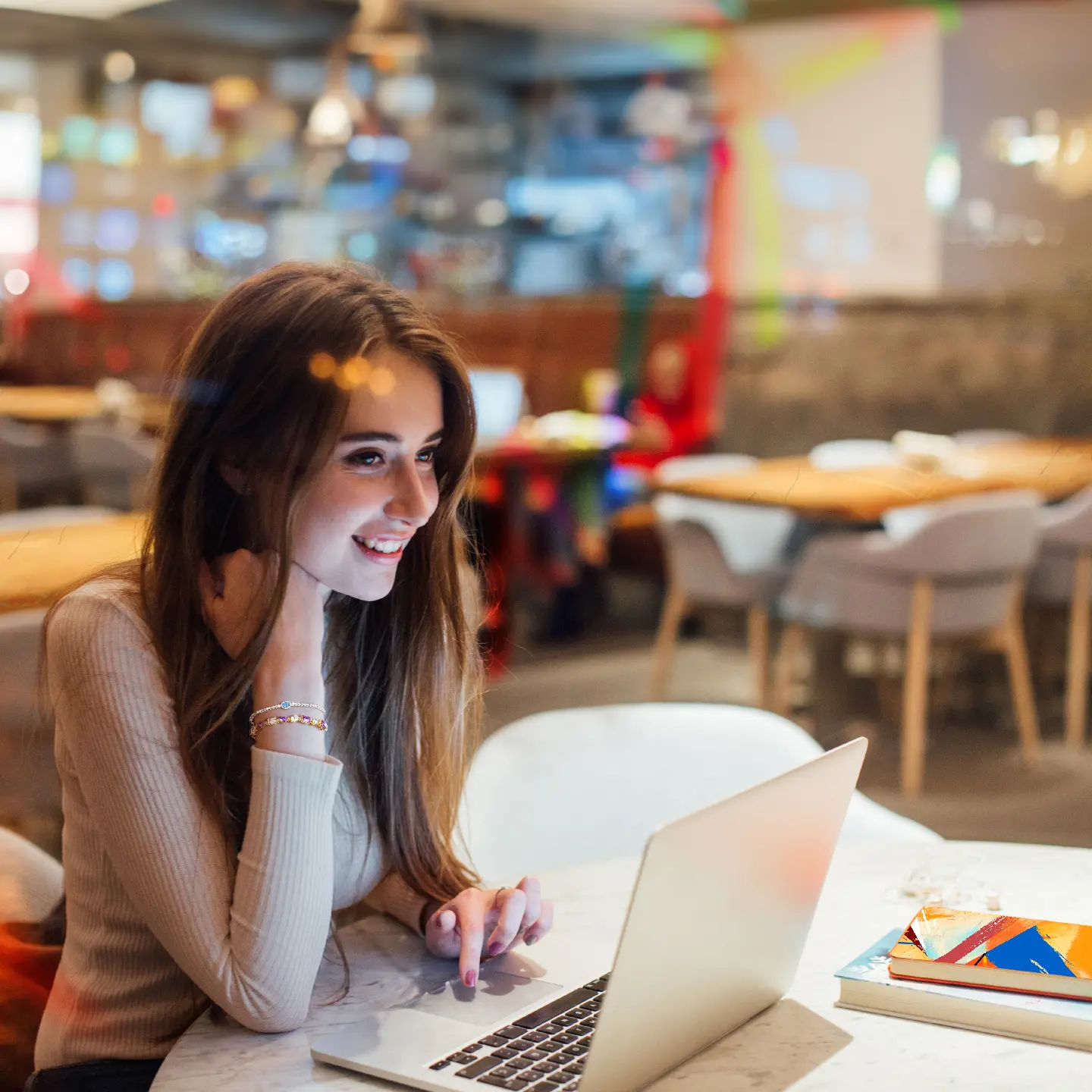 How Qnet Products Empower Women To Take Charge While Living Well 6 women sitting in a cafe on the computer smiling