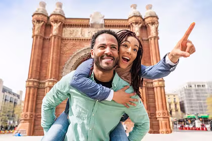 Man giving woman a piggy back ride in Europe while on a trip booked through a QVI holiday membership