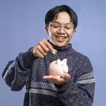 Guy symbolically saving his QNET earnings in a piggy bank