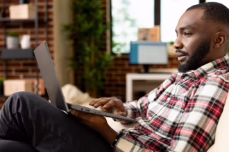 Man looking at laptop | Is QNET a Scam?