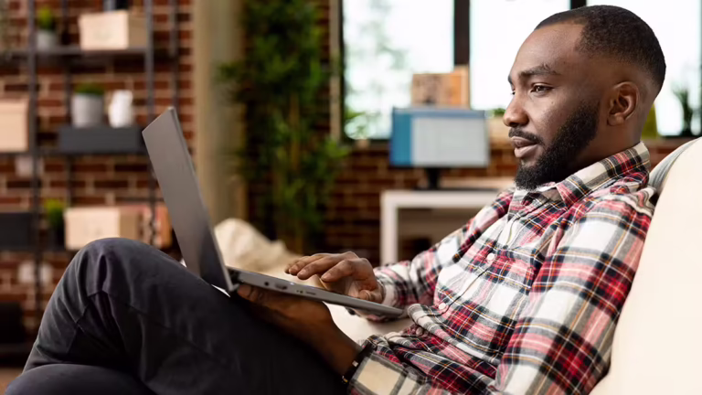 Man looking at laptop | Is QNET a Scam?