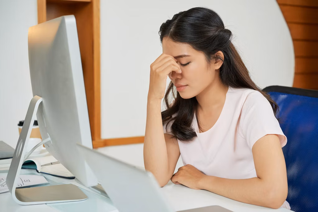 A girl experiencing eye strain while using an electronic device, highlighting the Amezcua E-Guard X.